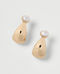 A pair of gold teardrop earrings with pearl accents rests on a plain white background. carousel Product Image 1