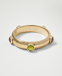 A gold ribbed bangle with colorful stones is displayed against a plain white background. carousel Product Image 2