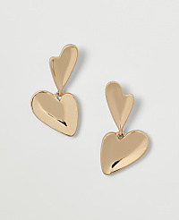 Two gold heart-shaped earrings hang against a plain white background. carousel Product Image 1