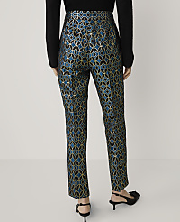 A person stands in front of a plain white background, wearing patterned teal and gold trousers and black heels. carousel Product Image 3