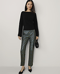 A woman in a black sweater and patterned pants stands against a plain background. carousel Product Image 4
