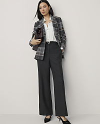 A woman in a plaid blazer and wide-leg pants stands against a plain white background, holding a burgundy handbag. carousel Product Image 1