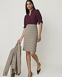 A woman in a plum blouse and plaid skirt stands against a plain background, holding a matching plaid jacket. carousel Product Image 3