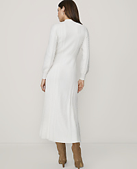 A woman in a white cable-knit dress and brown boots stands against a plain white background. carousel Product Image 2