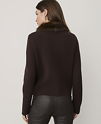 A woman in a brown fur-trimmed sweater and dark pants stands against a plain gray background. carousel Product Image 2