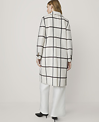 A woman in a white and black checkered coat and white pants stands against a plain white background. carousel Product Image 2