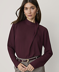 A woman in a burgundy blouse and plaid pants stands against a plain gray background. carousel Product Image 1