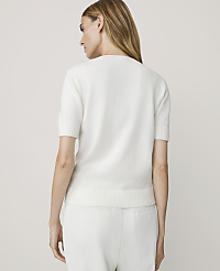 A woman in a white short-sleeved sweater and pants stands against a plain white background. carousel Product Image 2