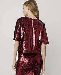 A woman in a sparkling red sequined top and skirt stands against a plain white background. carousel Product Image 2