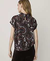 A woman in a dark brown paisley-patterned blouse stands against a plain, light background. carousel Product Image 2