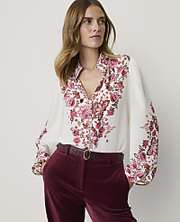 A woman in a white floral blouse and burgundy velvet pants stands against a plain background. carousel Product Image 1