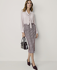 A woman in a pink bow-neck blouse and plaid pencil skirt stands with a handbag and burgundy loafers against a plain, light-colored background. carousel Product Image 3