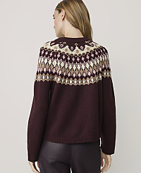 A woman in a burgundy sweater with a fair isle pattern stands against a plain, light background. carousel Product Image 2