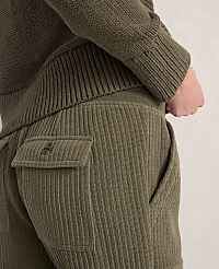 A person's back is shown wearing a green ribbed sweater and corduroy pants with a buttoned pocket. carousel Product Image 2