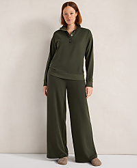 A woman in a green loungewear set stands against a plain, light-colored wall. carousel Product Image 3