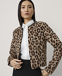 A woman in a leopard print jacket and white shirt stands against a plain, light gray background. carousel Product Image 1