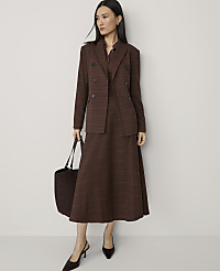 A woman in a brown plaid suit and heels stands with a tote bag against a plain, light-colored wall. carousel Product Image 4