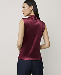 A woman in a burgundy velvet top and dark jeans stands against a plain, light gray background. carousel Product Image 2