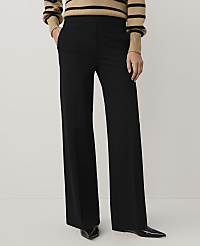 A person wearing a striped tan and black sweater with wide-leg black trousers and pointed black heels stands against a plain light gray background. carousel Product Image 2