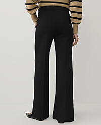 A person wearing a striped tan and black sweater and wide-leg black trousers stands against a plain white background. carousel Product Image 3