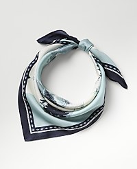 A blue and white patterned silk scarf is tied in a knot against a plain light gray background. carousel Product Image 1