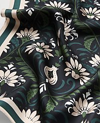 A draped black fabric featuring cream and green floral patterns in the foreground, with a matching patterned border visible in the background. carousel Product Image 2