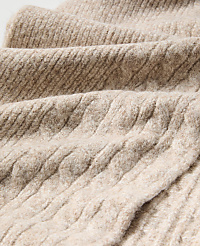 Close-up of textured, beige ribbed fabric folding in the foreground against a soft, blurred background of the same material. carousel Product Image 2