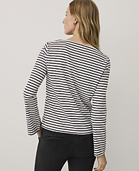 A woman wearing a black and white striped long-sleeve shirt and black jeans stands against a plain light gray background. carousel Product Image 2