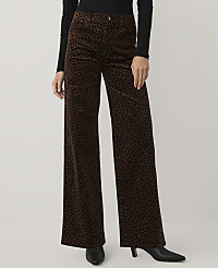 A person wearing a black top and brown leopard-print wide-leg trousers stands against a plain light gray background. carousel Product Image 2