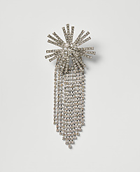 A sparkling rhinestone brooch with a sunburst top and cascading fringe is centered against a plain, light gray background. carousel Product Image 1