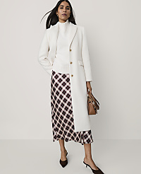A woman wearing a white coat, white turtleneck, and a plaid skirt stands against a plain white background. carousel Product Image 3
