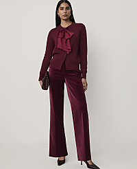 A woman wearing a burgundy bow-accented cardigan and matching velvet wide-leg trousers stands against a plain white background. carousel Product Image 3