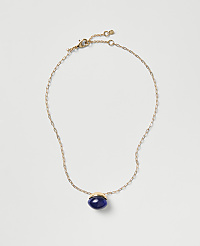 A gold chain necklace with a blue oval pendant rests on a plain light gray background. carousel Product Image 1