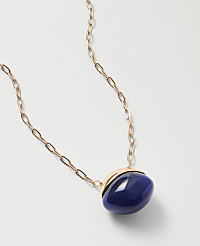A gold chain necklace with a large, oval blue stone pendant rests on a plain white background. carousel Product Image 2