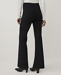 A person wearing a white long-sleeved top, black flared trousers, and black heels stands against a plain light gray background. carousel Product Image 4