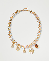 A gold chain necklace with various charms rests against a plain white background. carousel Product Image 1