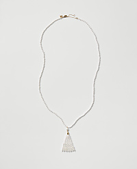 A white pearl necklace with a tassel pendant rests on a plain light gray background. carousel Product Image 1