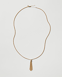 A gold chain necklace with a tassel pendant rests against a plain light gray background. carousel Product Image 1