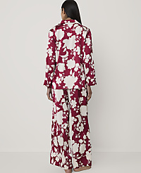 A woman stands with her back to the camera wearing red and white floral pajamas against a plain, light-colored background. carousel Product Image 2