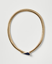 A gold ribbed necklace with a dark blue teardrop-shaped pendant rests on a plain light gray background. carousel Product Image 1
