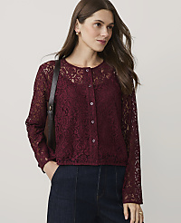 A woman wearing a burgundy lace top and dark blue jeans stands against a plain, light-colored background. carousel Product Image 1