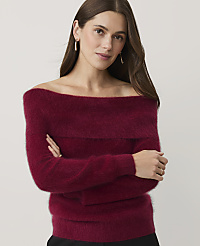 A woman wearing a burgundy off-the-shoulder sweater stands with her arms crossed against a plain, light-colored background. carousel Product Image 1