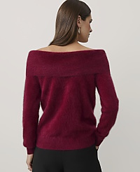 A woman wearing a fuzzy burgundy off-the-shoulder sweater and black pants stands with her back to the camera against a plain light gray background. carousel Product Image 2