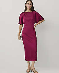 A woman wearing a magenta satin midi dress and gold heels stands against a plain white background. carousel Product Image 1
