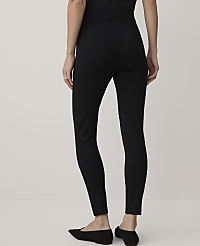 A person wearing black slim-fit trousers and black flats stands against a plain, light-colored background. carousel Product Image 3
