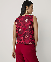 A woman wearing a red floral sleeveless top and matching red trousers stands against a plain, light-colored background. carousel Product Image 2