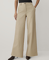 A person wears wide-leg beige trousers and dark shoes against a plain light gray background. carousel Product Image 2