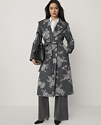 A woman wearing a grey floral-patterned wrap coat and wide-leg trousers stands against a plain white background. carousel Product Image 1