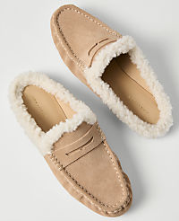 A pair of tan suede loafers with white faux-fur lining rests on a plain white background. carousel Product Image 2