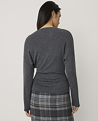 A woman seen from behind wears a dark grey long-sleeved top and a plaid skirt against a plain light grey background. carousel Product Image 2